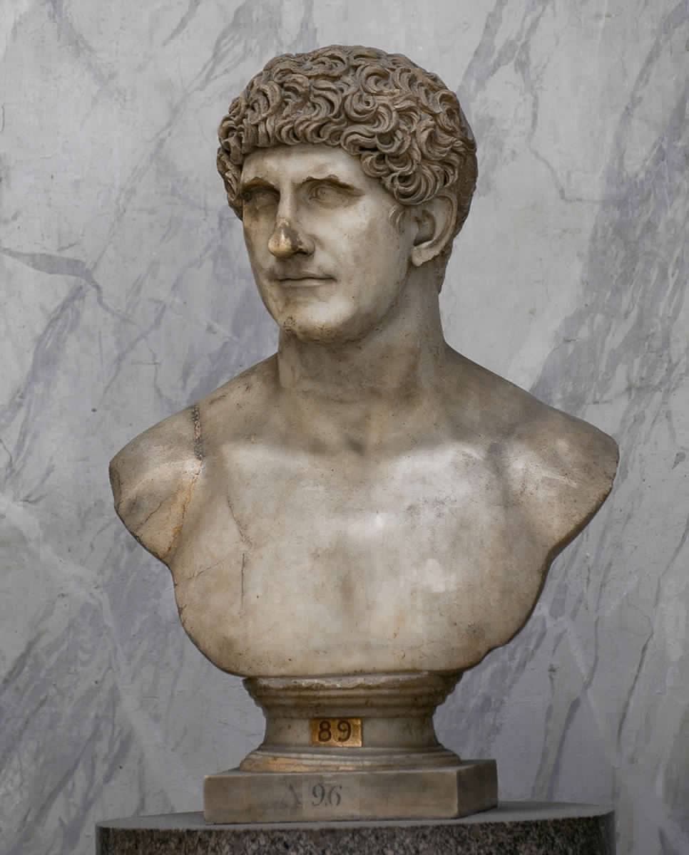 A marble bust of a curly-haired man with a strong jaw