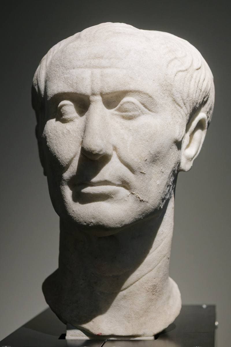 A marble head of a thin, lined, balding man