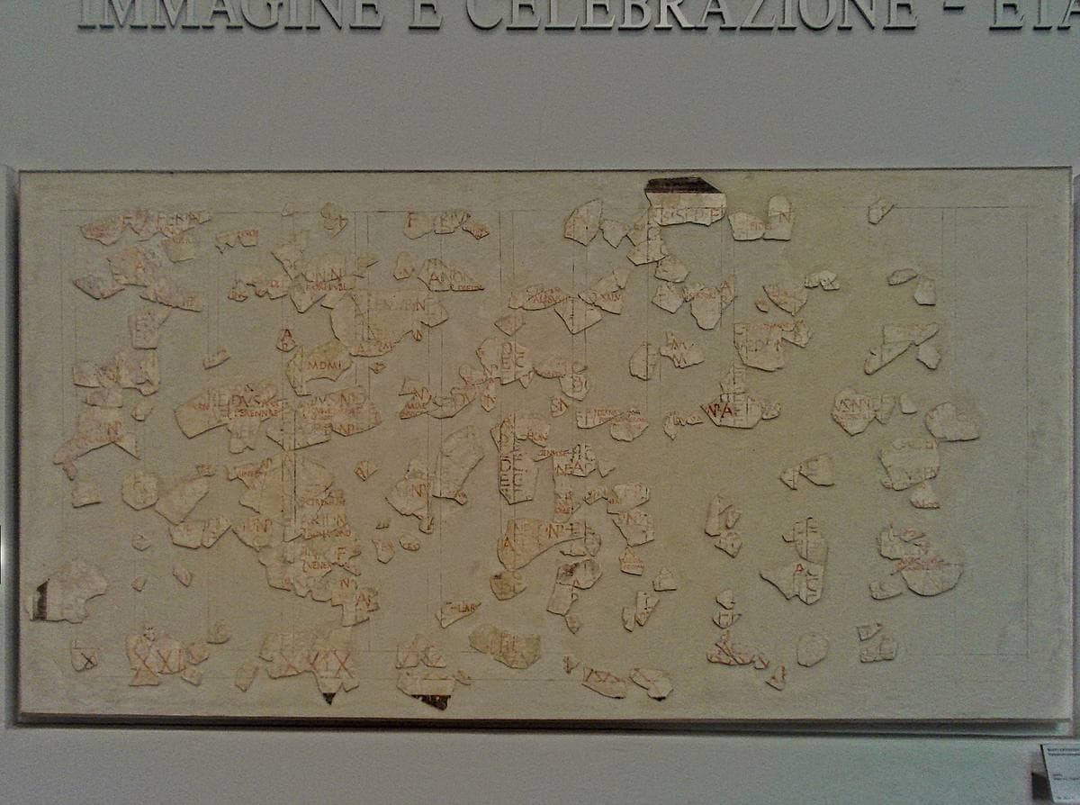 Fragments of a painted plaster calendar with columns of small red and black letters