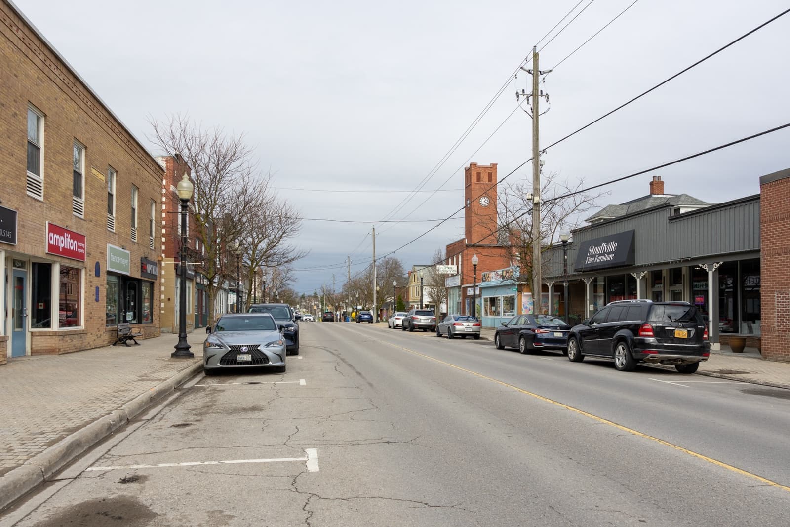 A wide small-town main street with shops and parked cars