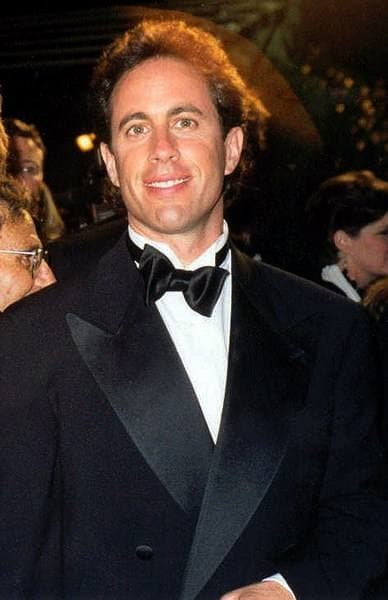 Jerry Seinfeld smiling in a tuxedo and bow tie