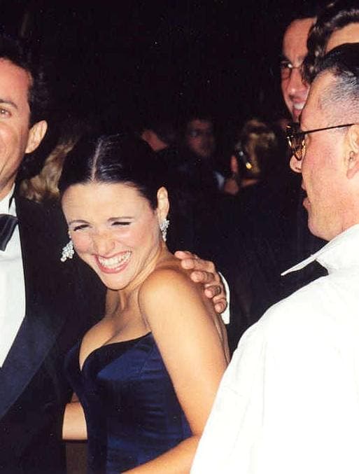 Julia Louis-Dreyfus laughing, in a dark blue strapless dress