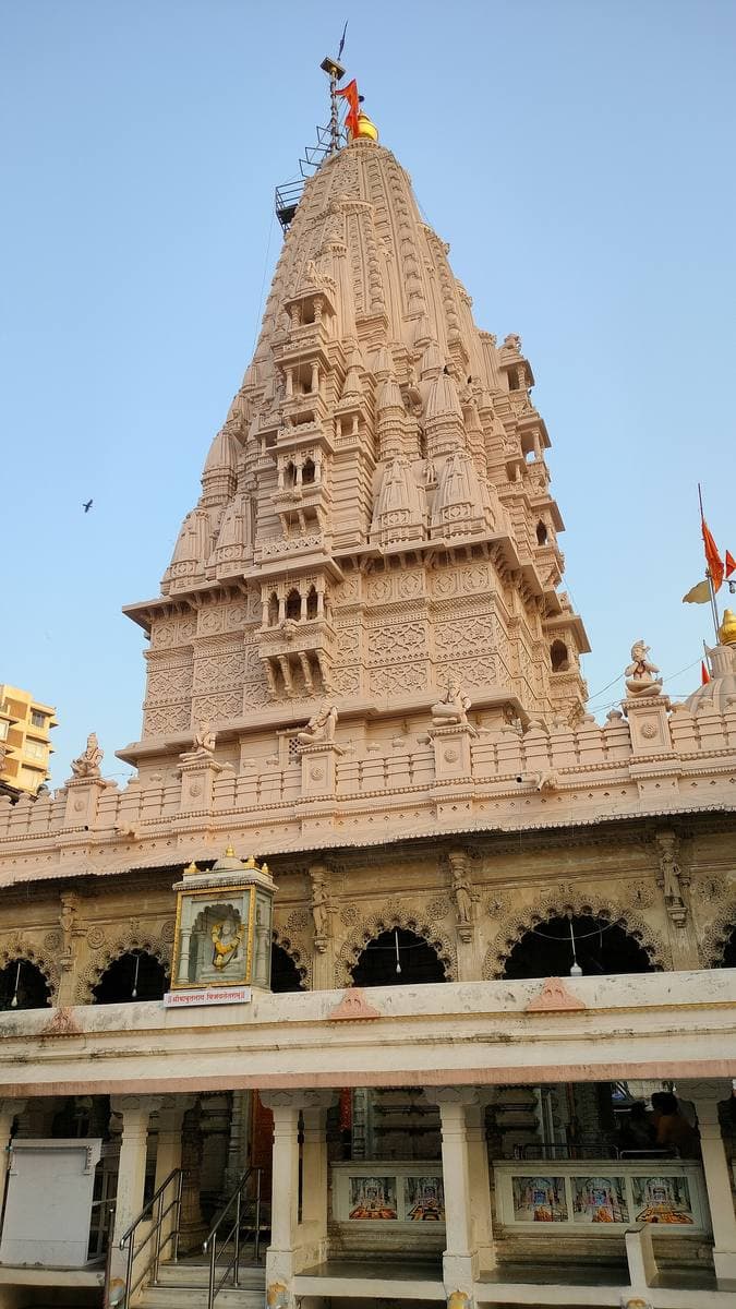 The carved white spire of a Hindu temple against the sky