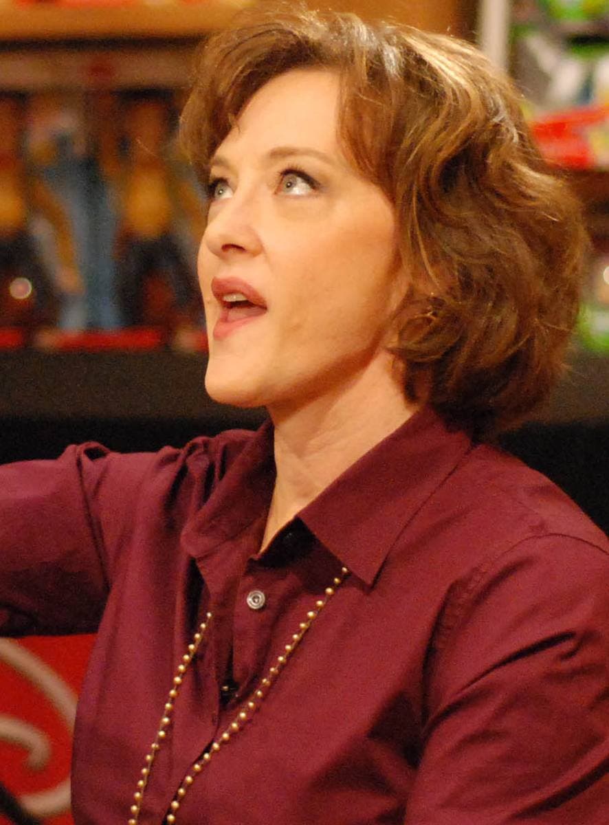 Joan Cusack in a red shirt, mid-sentence