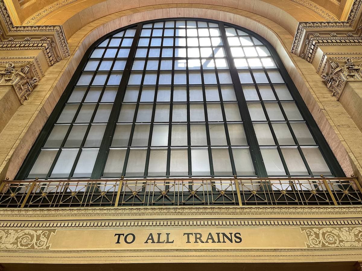 A barrel-vaulted skylight over a great hall, with the words To All Trains