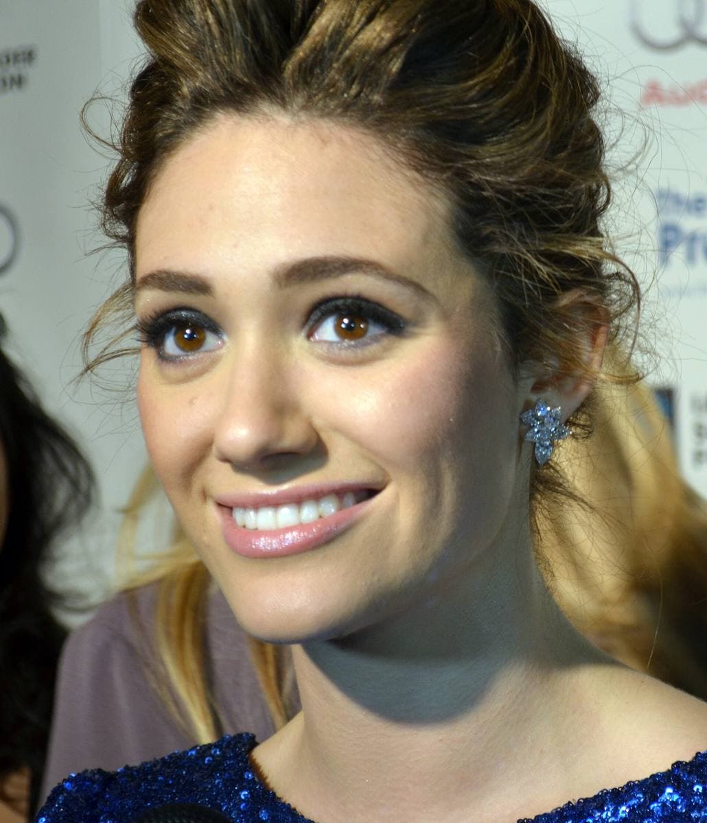 Emmy Rossum smiling, hair pinned up, in a dark sequinned top