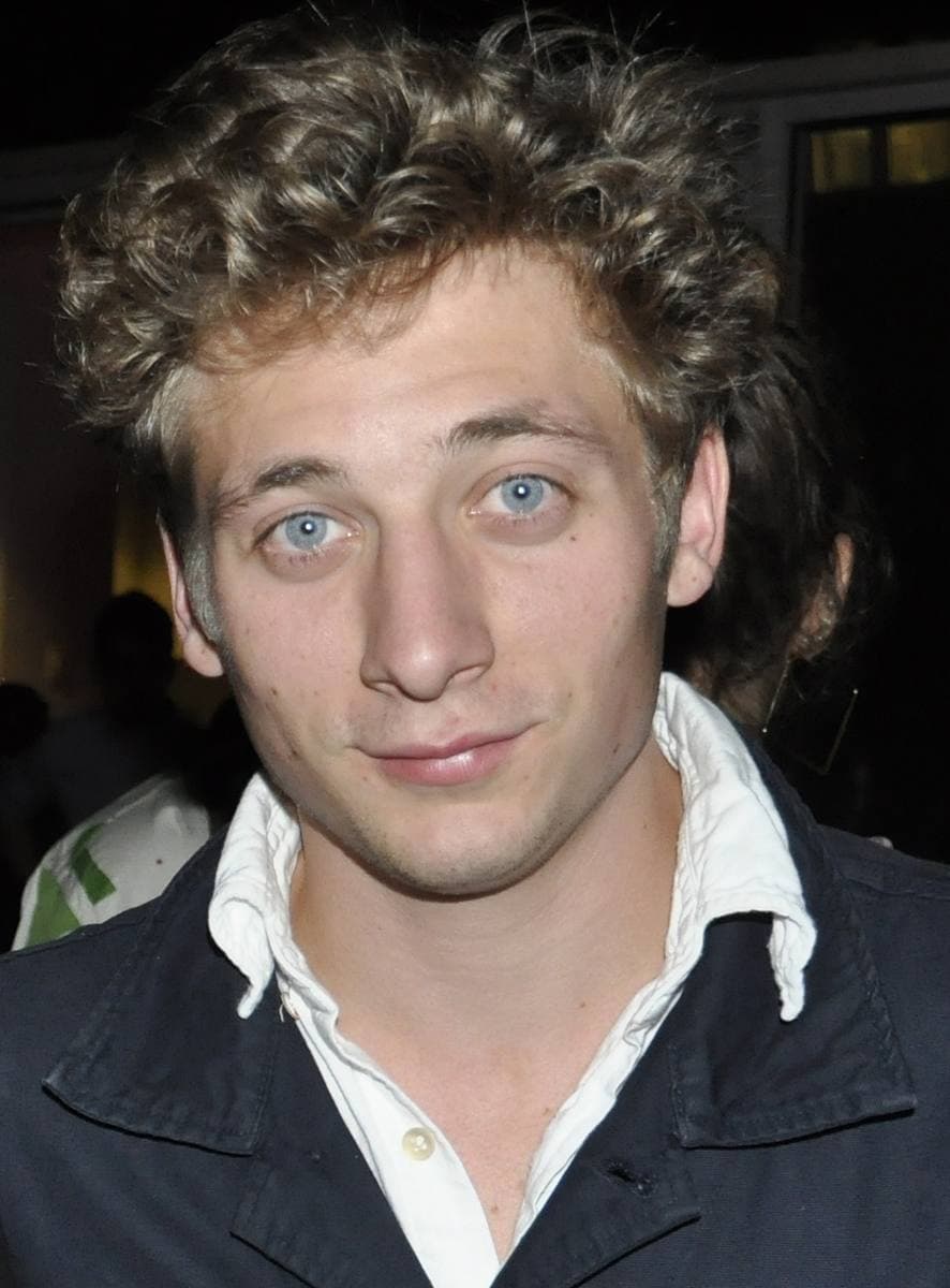 Jeremy Allen White with curly hair and an open-necked shirt