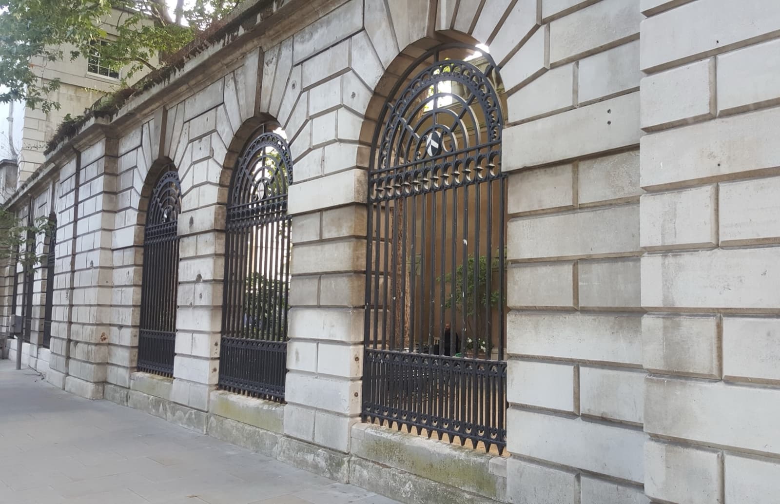 The pale stone screen wall and arched gateways of St Bartholomew’s Hospital