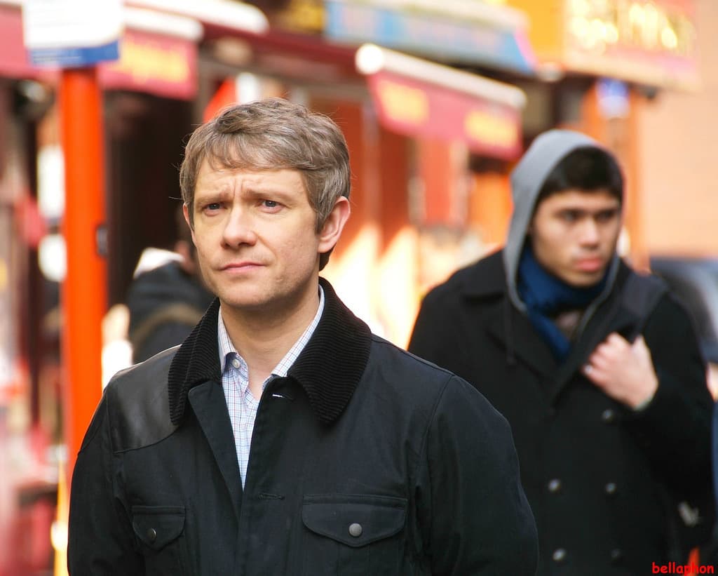 Martin Freeman in a dark jacket on a busy Chinatown street