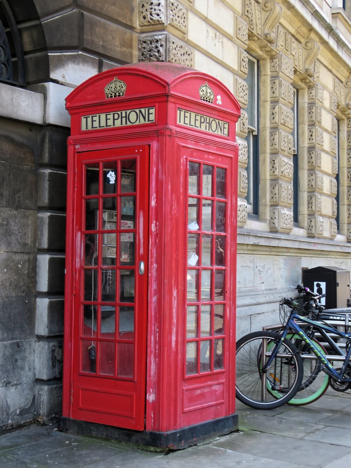 A red telephone box against the stone wall of St Bartholomew’s Hospital
