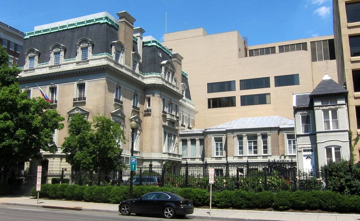A grand Beaux-Arts mansion behind railings on a city street