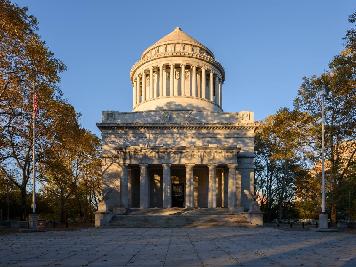 A domed granite mausoleum with columns behind a wide plaza