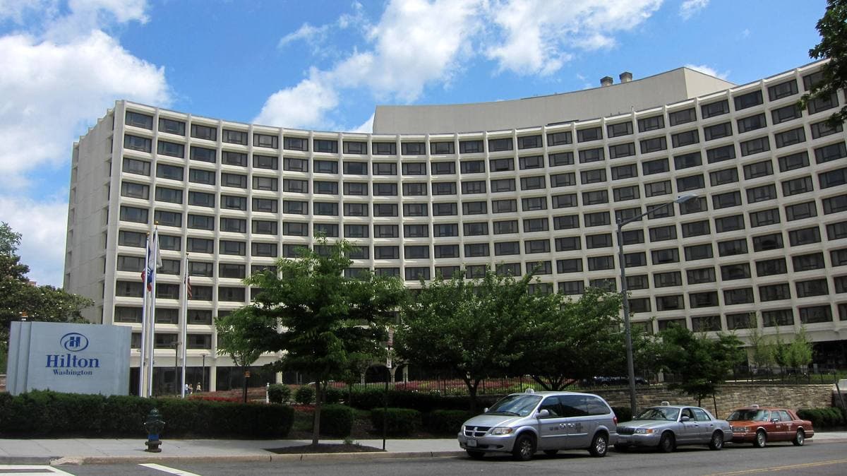 A curving white hotel building above a side street