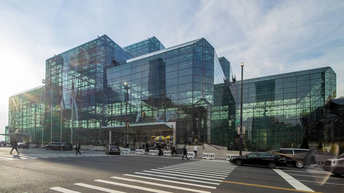A long glass building with a dark space-frame roof