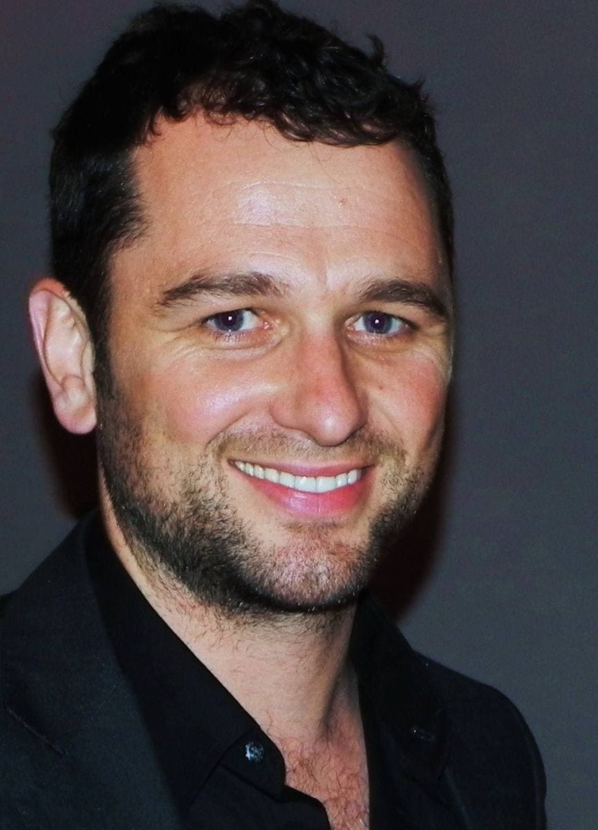 Matthew Rhys smiling, dark hair, black shirt