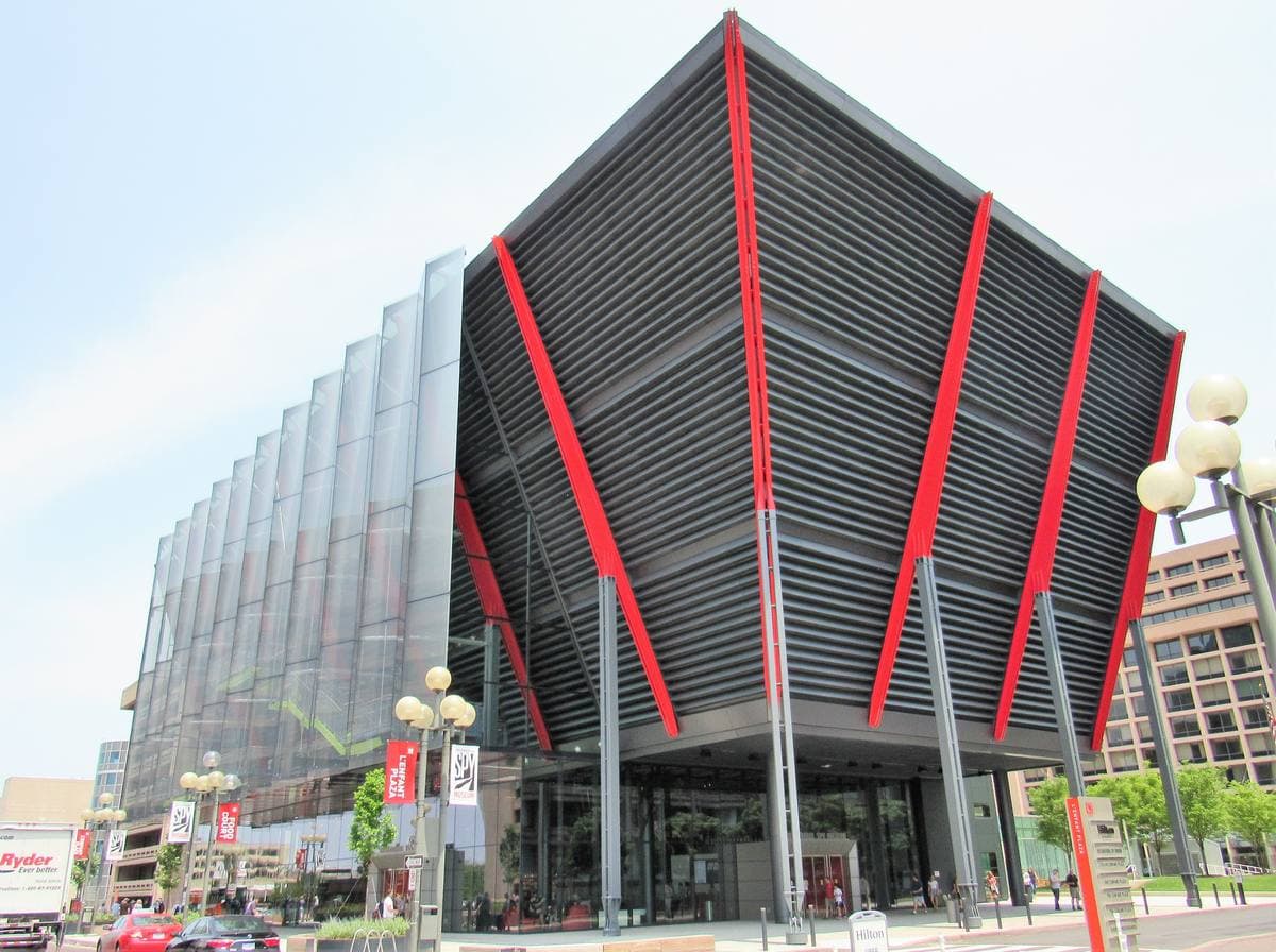 A dark angular building with a glass facade
