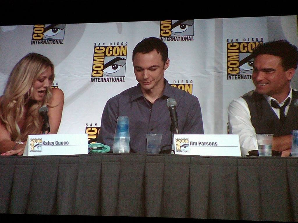 Kaley Cuoco, Jim Parsons and Johnny Galecki at a panel table with name cards and microphones