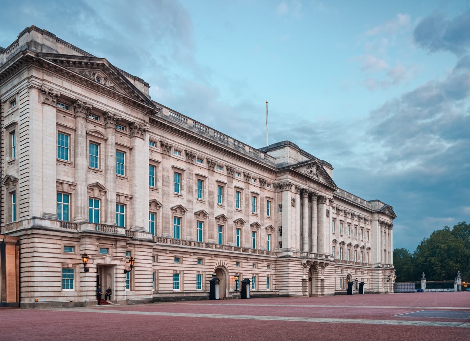 The pale stone east front of Buckingham Palace with its central balcony, seen from the forecourt at dawn