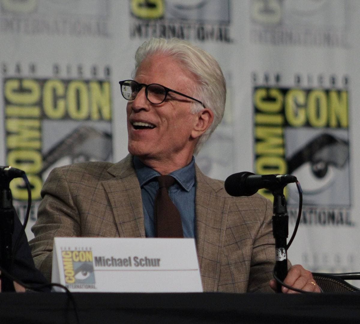 Ted Danson, white-haired, at a panel table