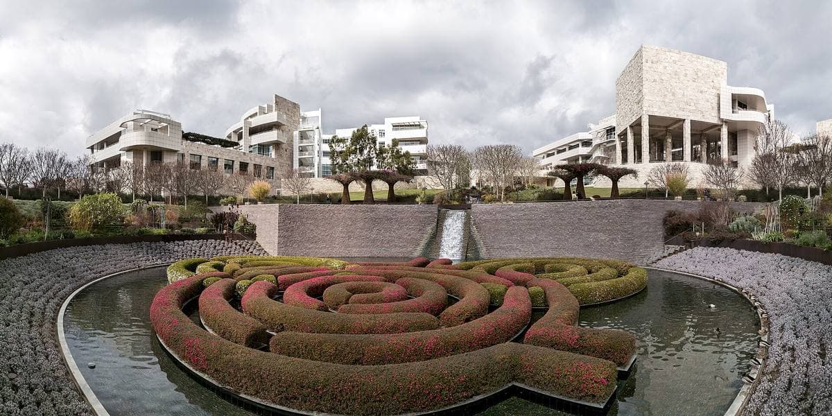 White stone and metal pavilions on a hill above terraced gardens