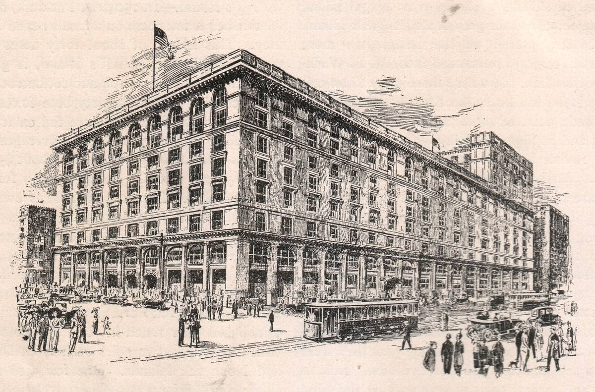 An old print of a long eight-storey stone department store filling a city block, with carriages on the avenue