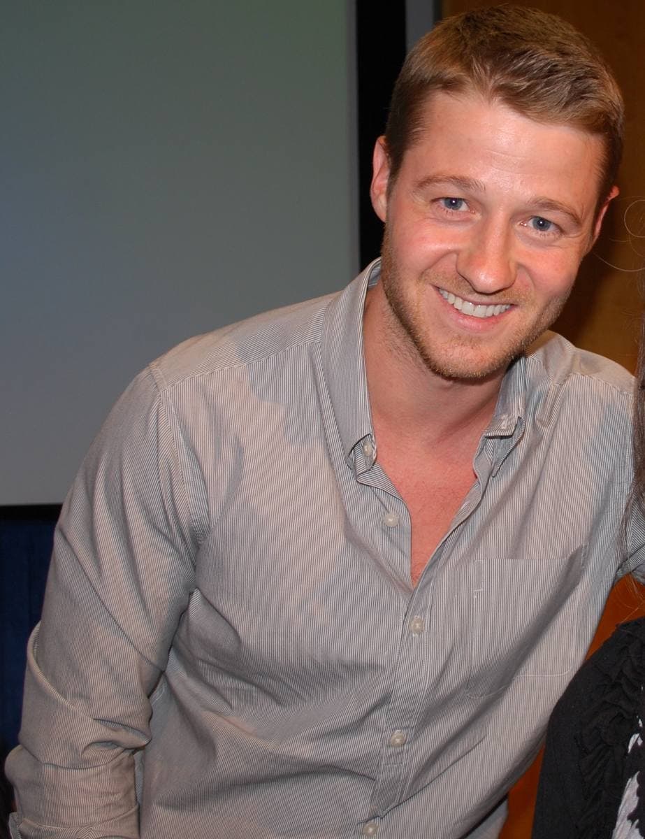 Ben McKenzie in a pale shirt, smiling broadly