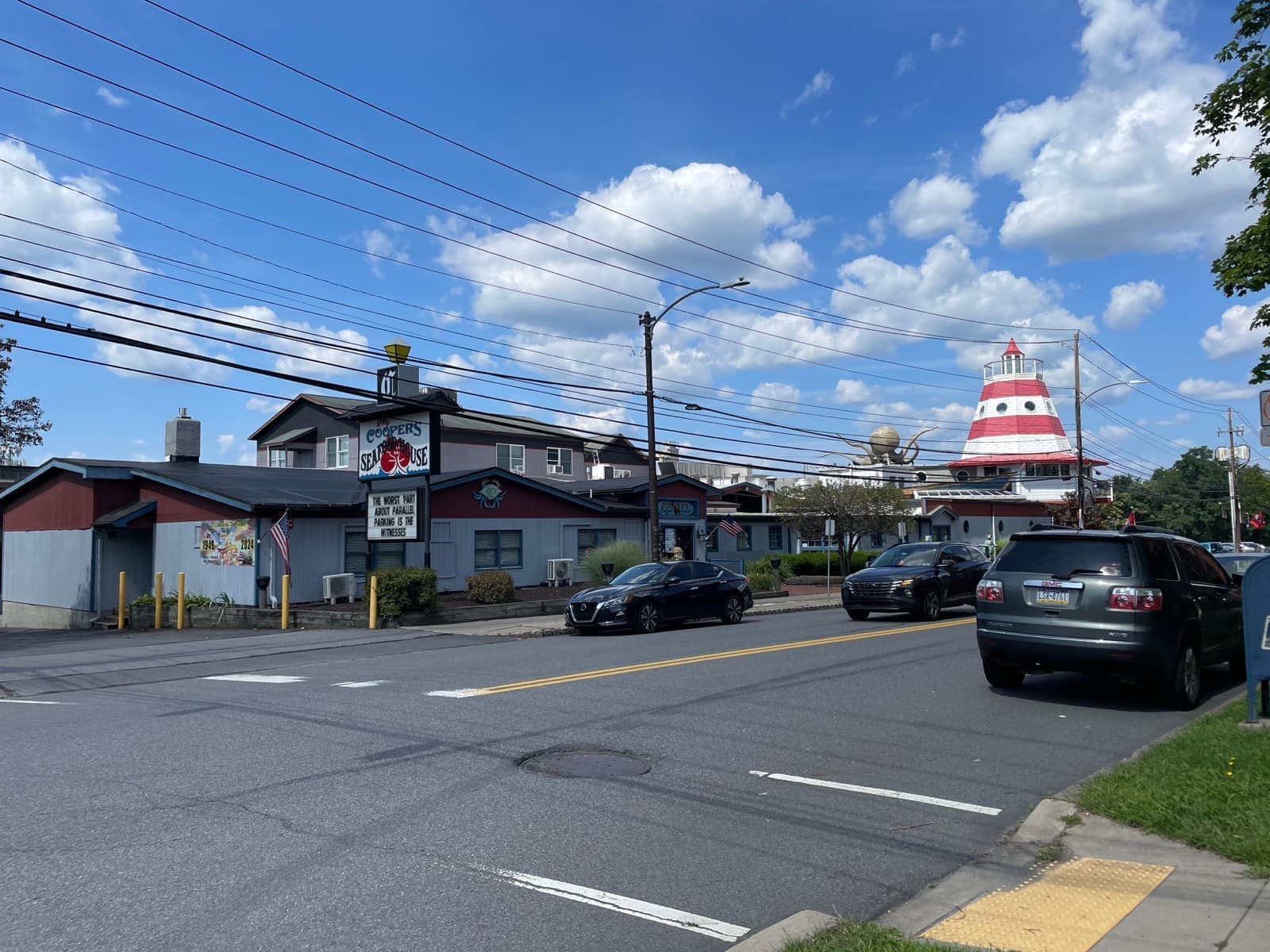A street corner with a restaurant building and a red-and-white lighthouse top above the roof