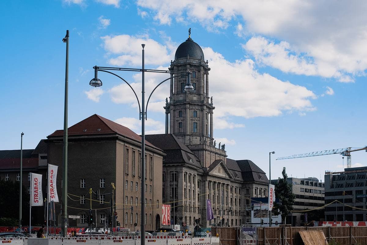 A large stone civic building with a domed tower under a blue sky