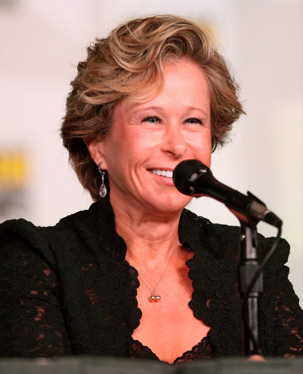 Yeardley Smith smiling at a microphone in a black lace top