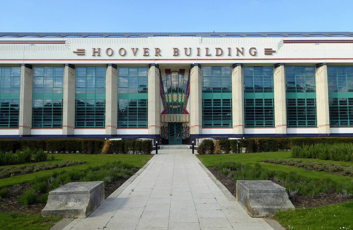 The long white Art Deco front of the Hoover Building with green glazing, behind a lawn