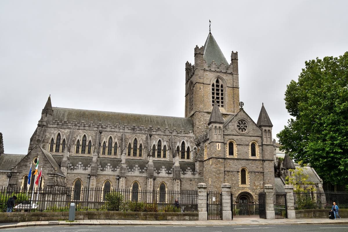 A grey stone Gothic cathedral with a square tower and pointed windows