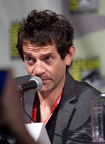 James Frain speaking into a microphone at a panel table