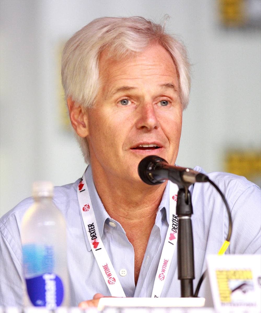 Chris Carter, white-haired, smiling, in a light shirt
