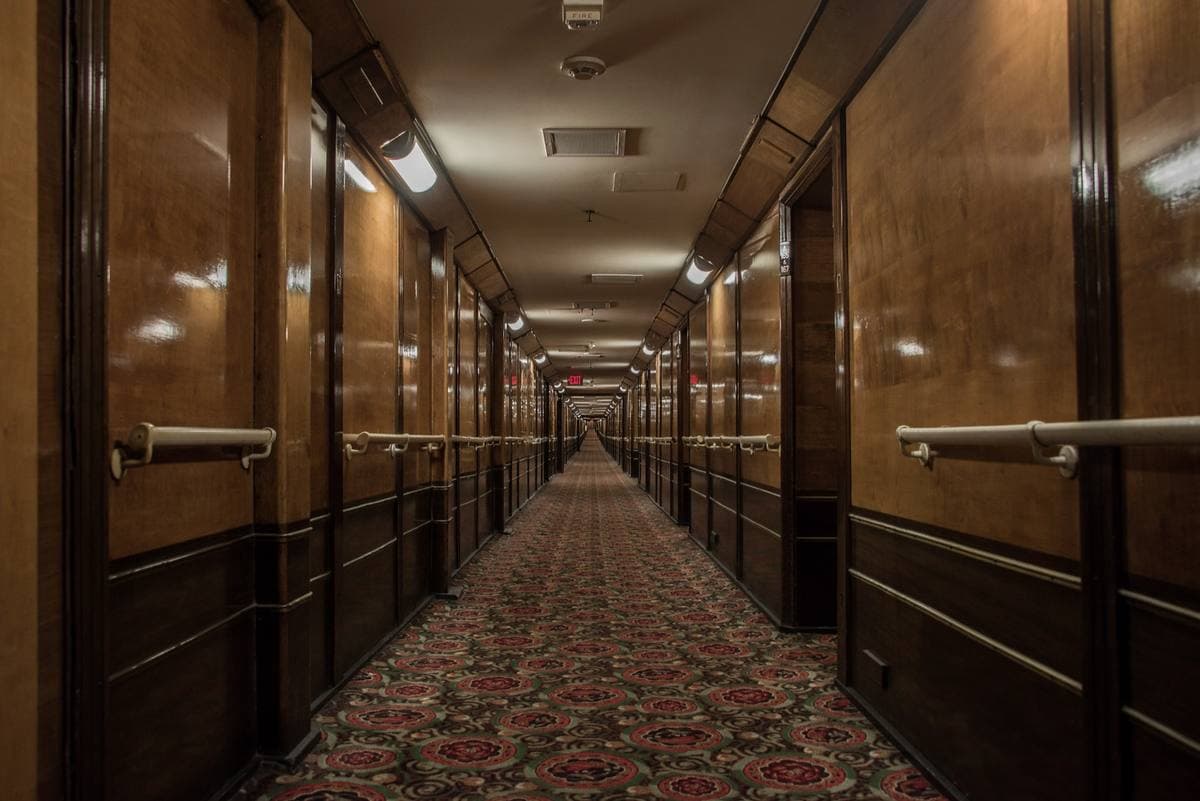 A long wood-panelled corridor inside the Queen Mary, stretching into the distance