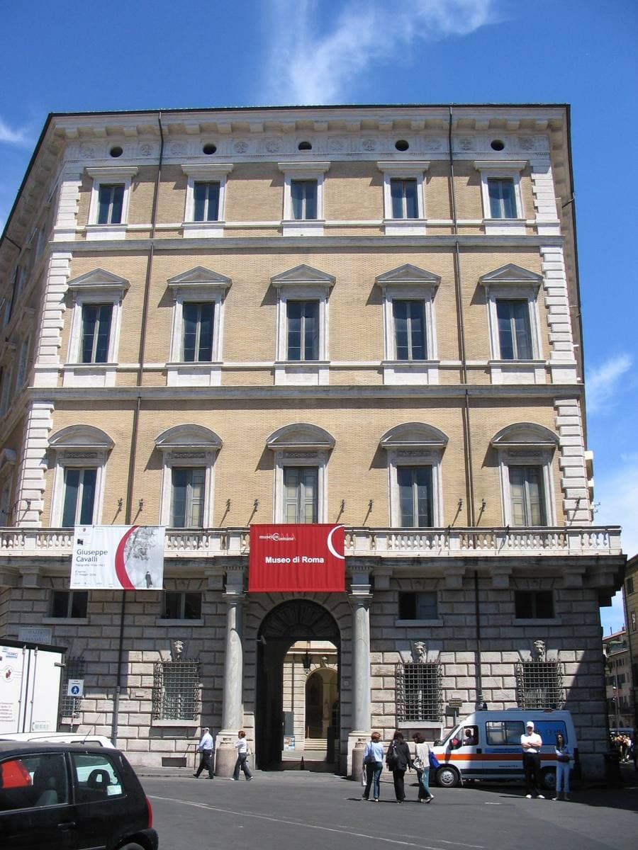 The ochre front of Palazzo Braschi with a red museum banner over the door