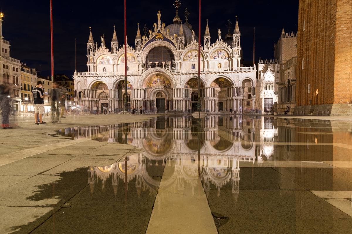 The basilica’s domes and arches mirrored in a thin sheet of water at night