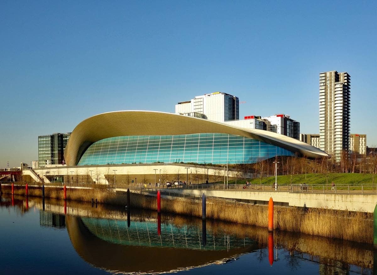 A swooping wave-shaped roof over a glass-walled building