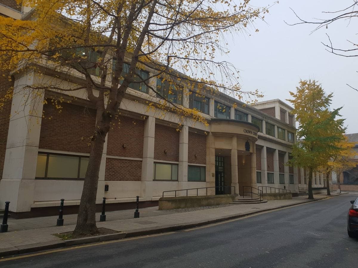 A plain post-war office-style building of brick and glass on a quiet street