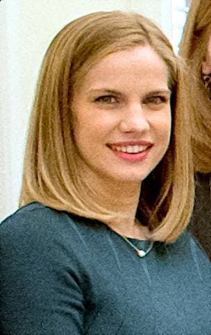 Anna Chlumsky smiling, in a green top, shoulder-length fair hair