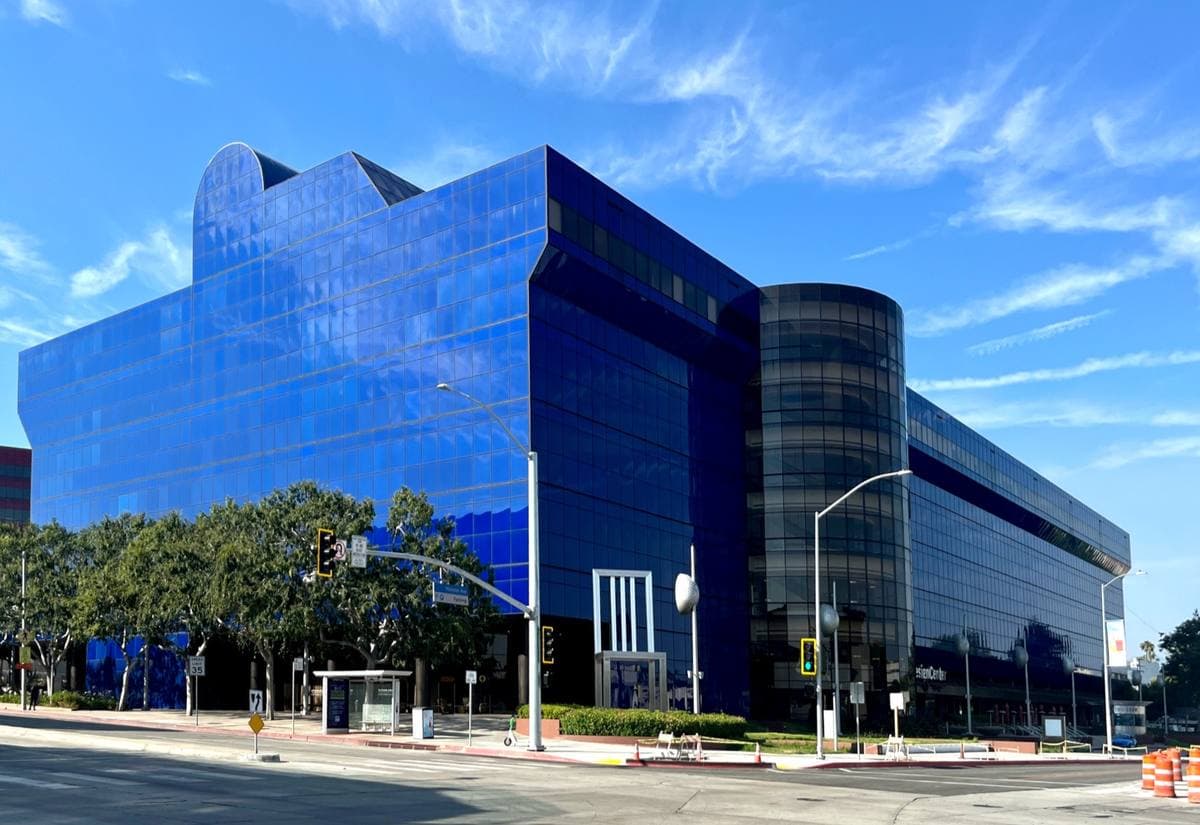 A blue glass building on a sunny street