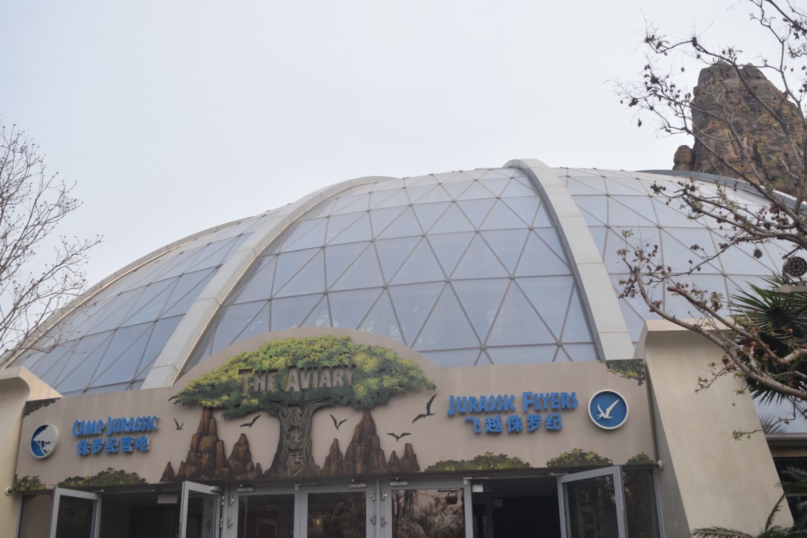 A glass-domed building with jungle rock work at its entrance