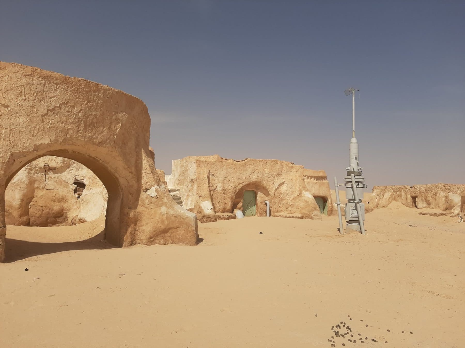 Domed adobe-style film-set buildings standing on desert sand