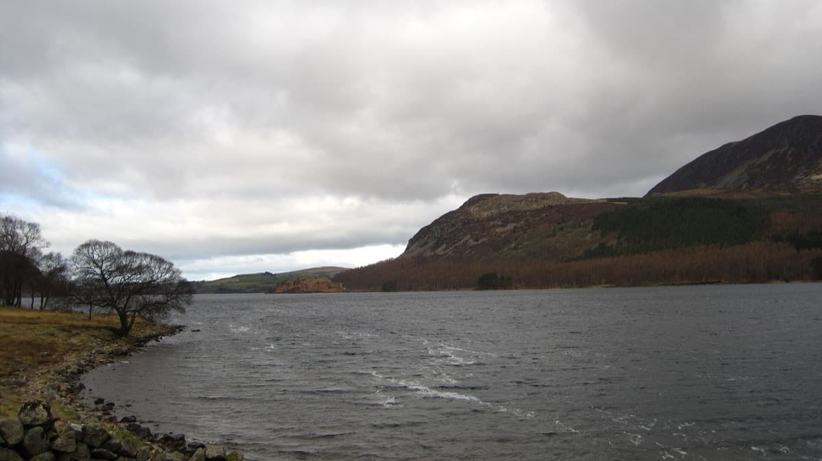 A long lake between fells under a pale sky