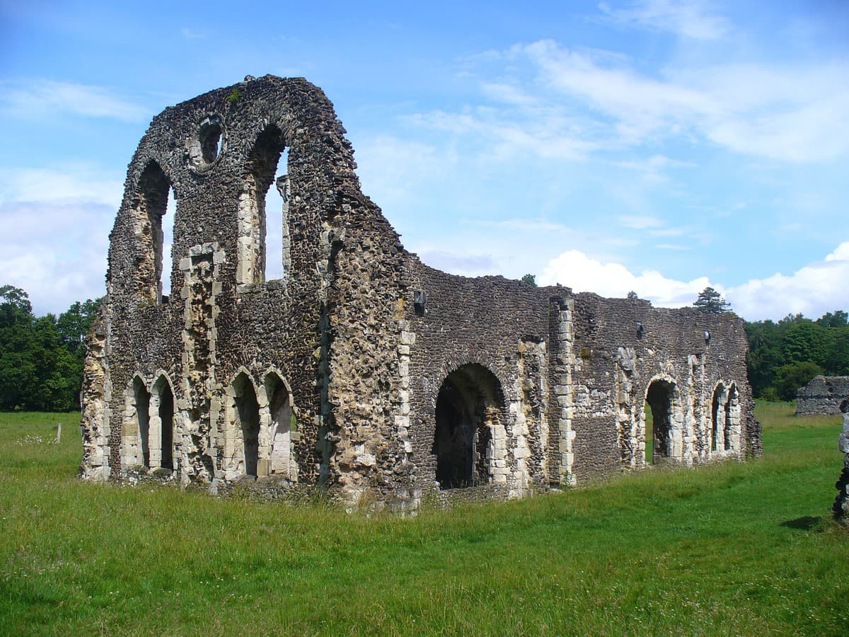 Ruined stone arches of an abbey in a green field