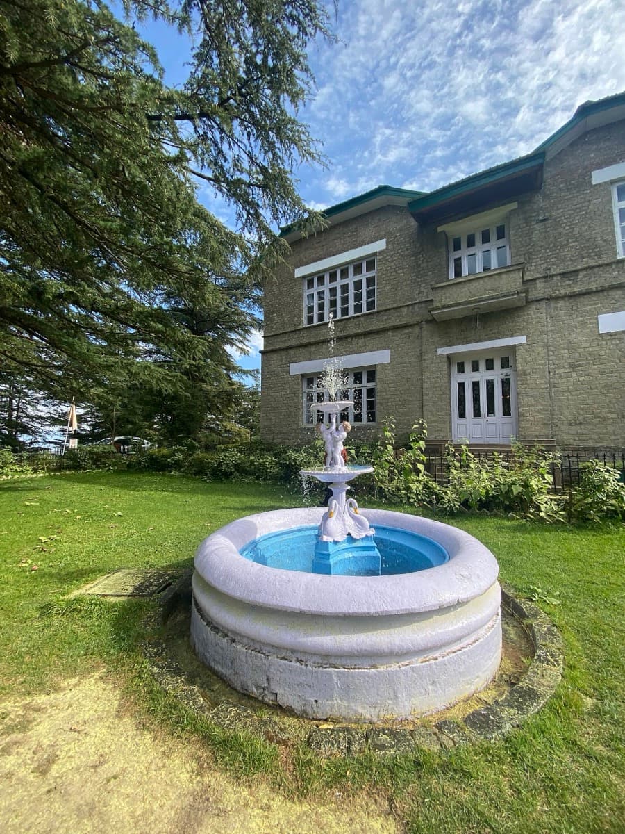 A large palace building with green lawns and tall trees