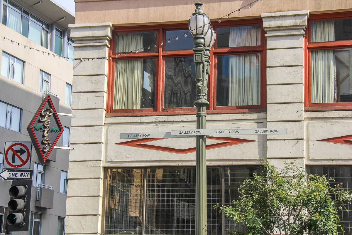 Red-framed upper windows and carved stone of an old building at a downtown corner