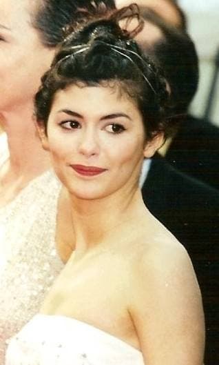 Audrey Tautou with her dark hair pinned up, smiling, in a white strapless dress