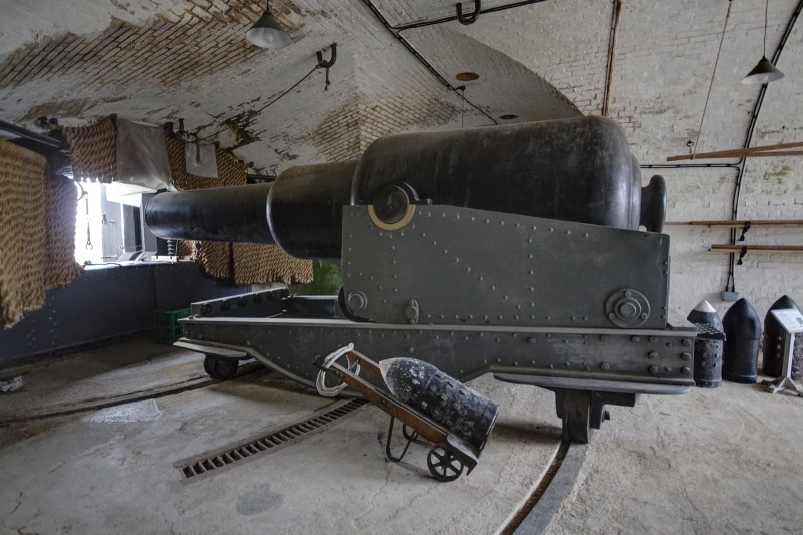 A huge Victorian gun on its iron carriage inside a vaulted brick casemate