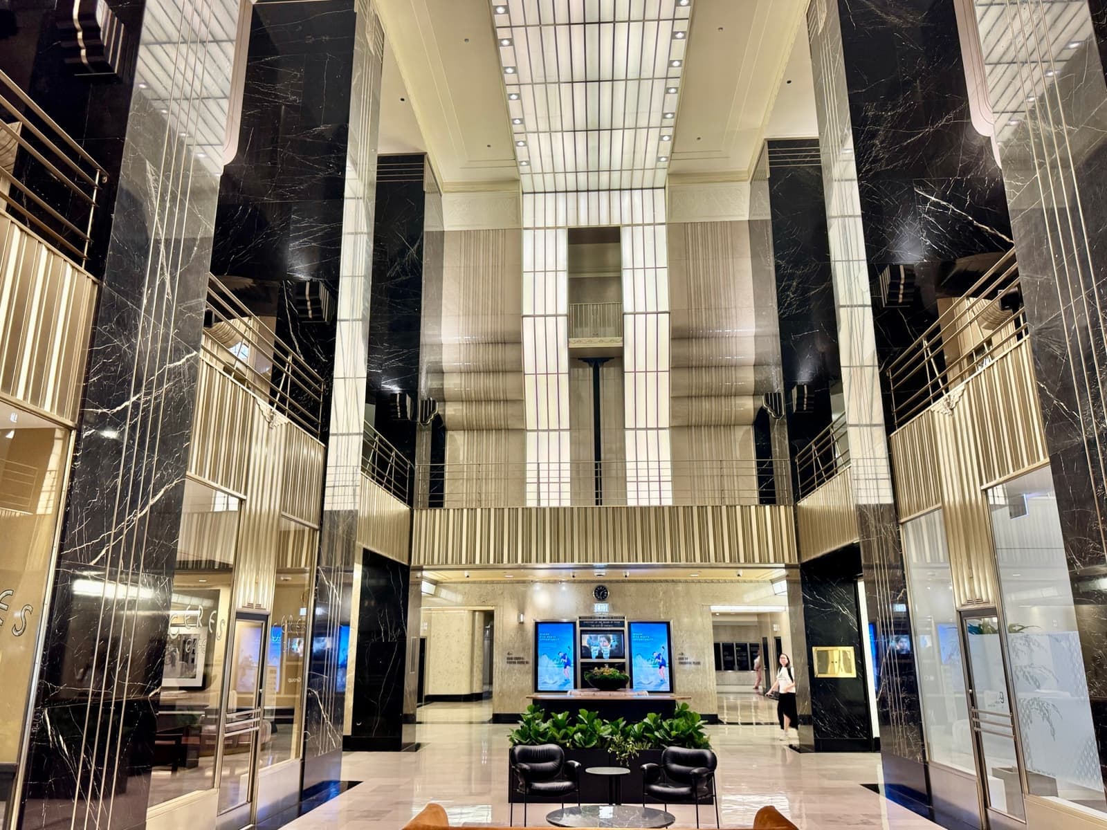 A tall Art Deco lobby in black marble and pale metal