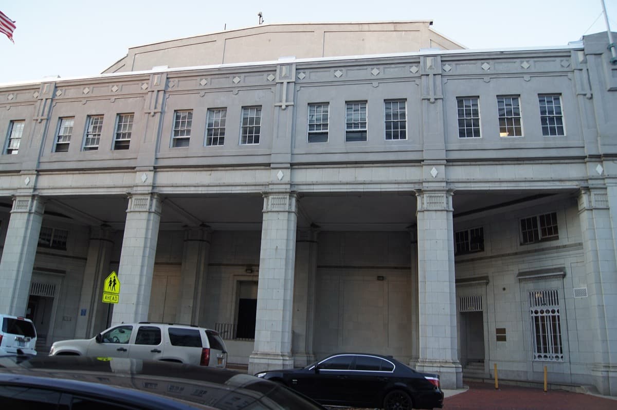 A brick studio building with tall windows on a corner in Queens